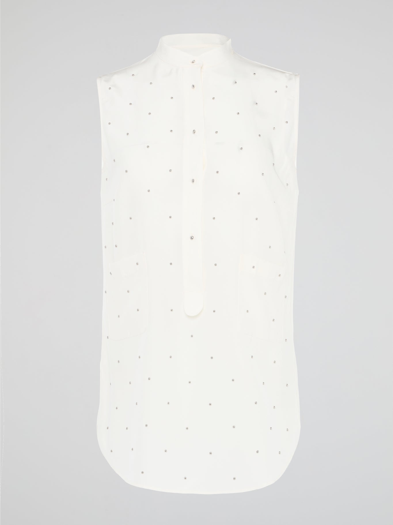 Unleash your fierce, fashion-forward side with the White Studded Sleeveless Shirt by Akris Punto. Crafted with meticulous attention to detail, this statement piece is adorned with intricately placed studs that exude edgy sophistication. Perfectly blending poise and rebellious spirit, this sleeveless shirt is a captivating must-have for those seeking to redefine their style game.