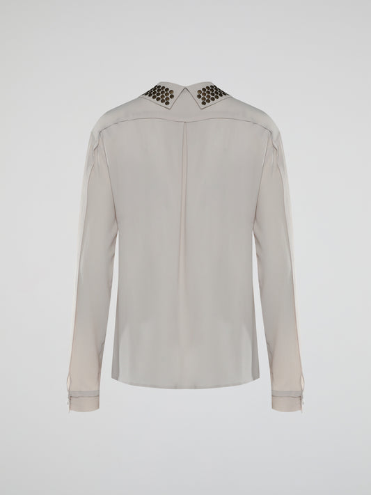 Indulge in the perfect blend of elegance and edginess with the Beige Studded Collar Blouse from Roberto Cavalli. Crafted with meticulous attention to detail, this unique blouse features a beautifully adorned studded collar that adds a daring touch to a classic silhouette. Whether it's a formal event or a night out on the town, this statement piece will effortlessly elevate any ensemble and make heads turn your way.