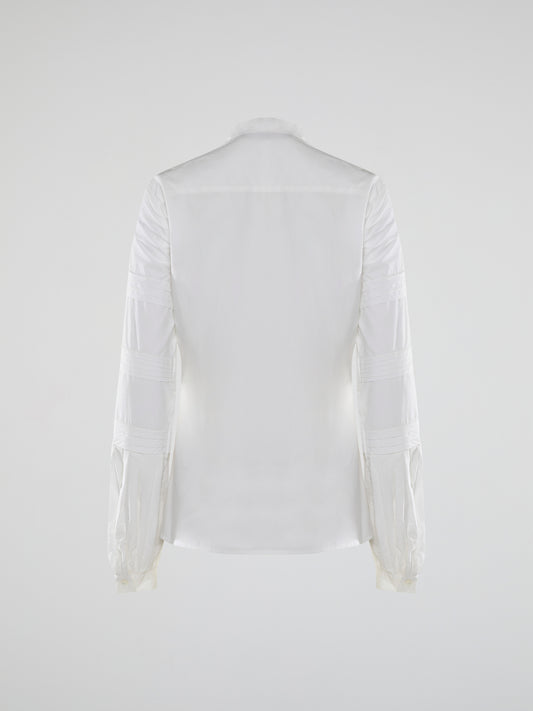 Step into the world of timeless elegance with the White Pleated Bib Shirt from Roberto Cavalli. Crafted with meticulous attention to detail, this masterpiece combines effortless sophistication with a touch of whimsical charm. From its delicate pleated bib to its crisp white fabric, this shirt will make a statement in any setting, exuding refined elegance that is truly captivating.