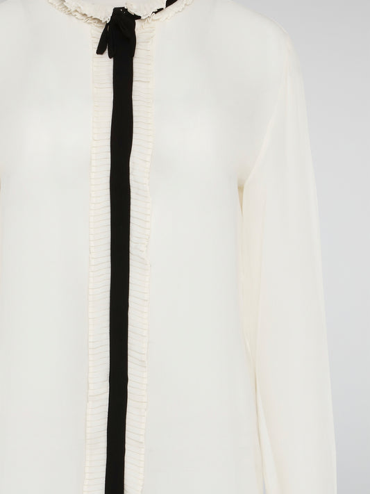 Step into luxury and sophistication with the Roberto Cavalli White Frill Detailed Blouse. The delicate frill detailing adds a touch of elegance to this classic white blouse, making it a perfect choice for any special occasion. Elevate your wardrobe with this timeless piece that exudes high-end fashion and style.